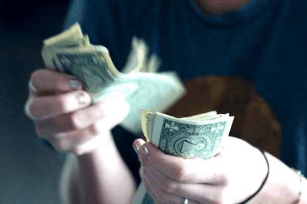 person counting money one dollar bills