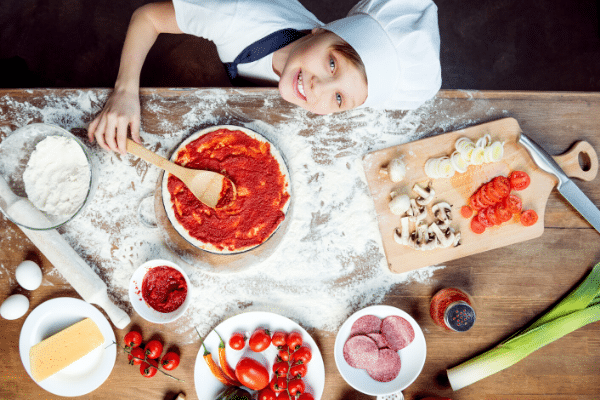 Child making homemade pizza