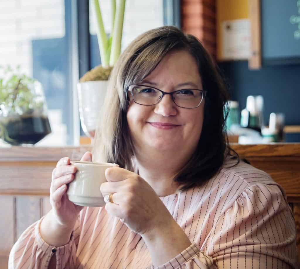 woman smiling and drinking coffee