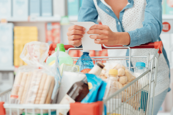 woman pushing grocery cart reading list Groceries