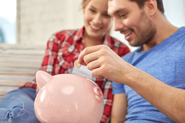 Couple adding money to a piggy bank