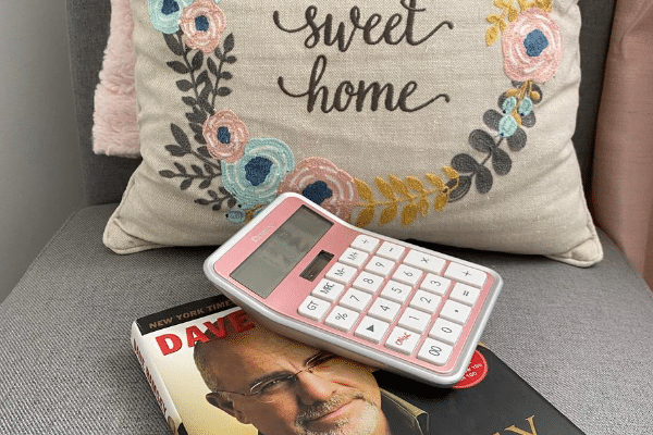 dave ramsey book on a chair with a calculator