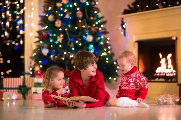 children reading near Christmas tree