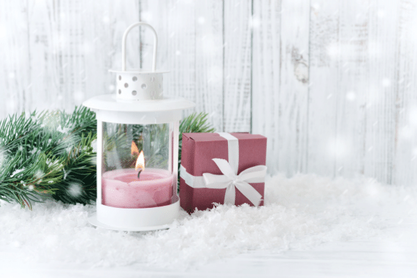 evergreen branch, snow, candle and gift