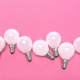 7 lightbulbs on a pink table