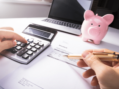 calculator, piggy bank and man budgeting when you get paid once a month