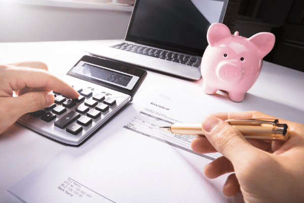 calculator, piggy bank and man budgeting when you get paid once a month