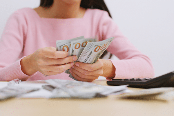 woman in pink shirt counting money