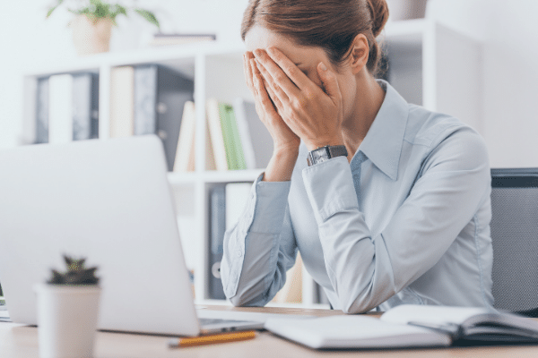 woman with hand in face looking at computor