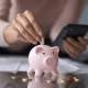 woman putting coins in piggy bank
