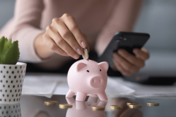 woman putting coins in piggy bank