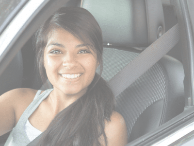 teen girl driving car smiling