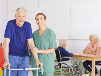 woman standing next to mature man walker other people wheel chair nurse