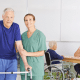 woman standing next to mature man walker other people wheel chair nurse