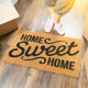 home sweet home door mat woman standing next to it moving boxes