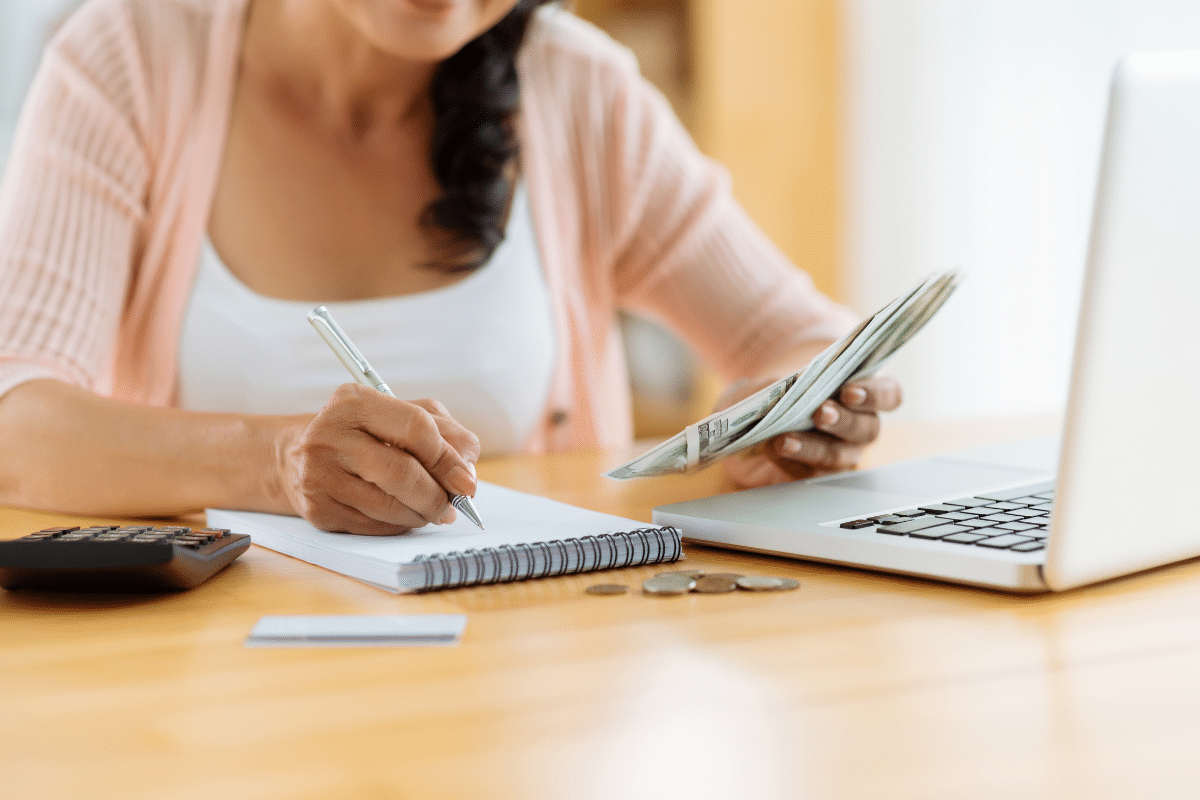 woman writing pen money calculator