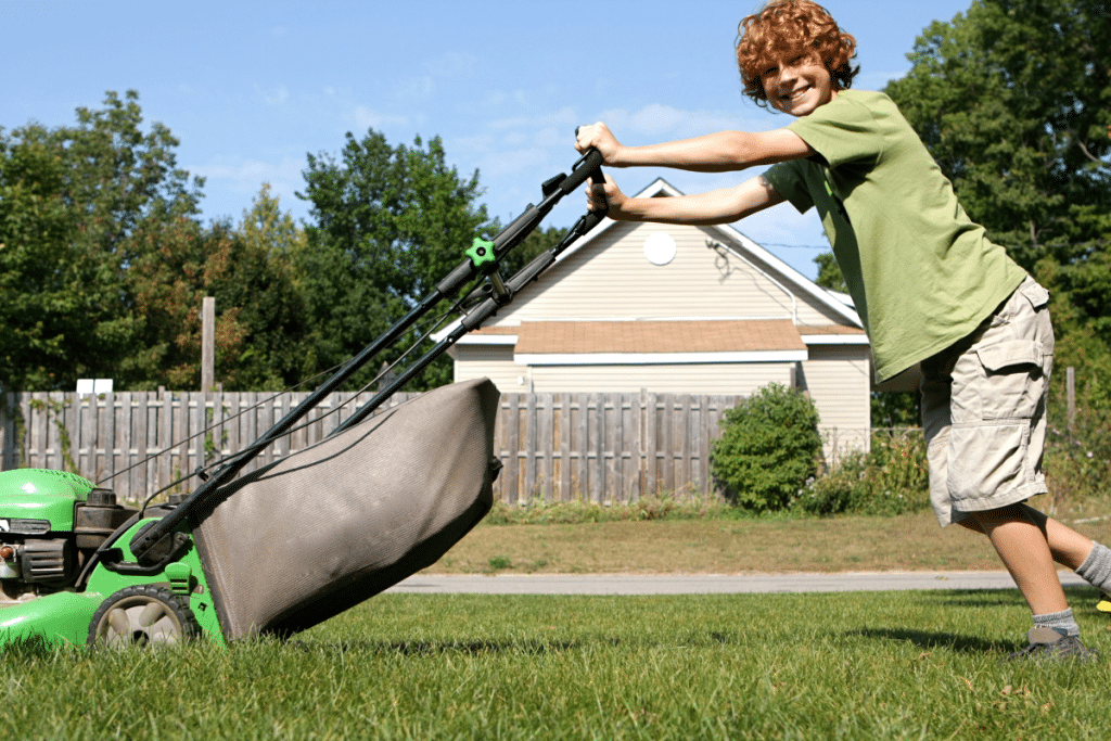 young boy mowing lawn
