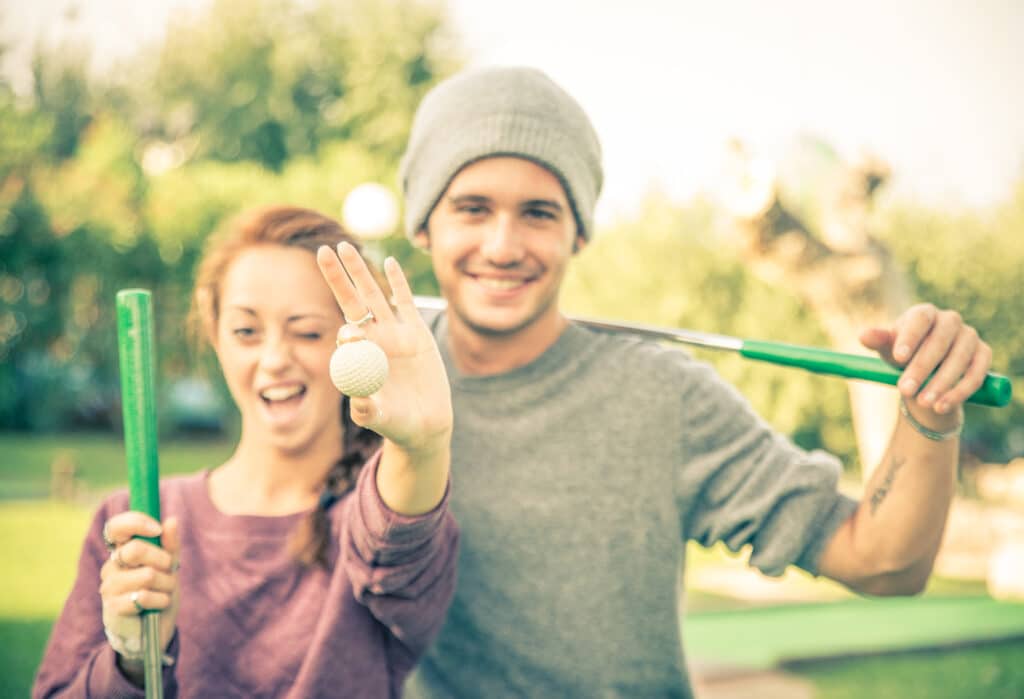 cute young couple playing mini golf