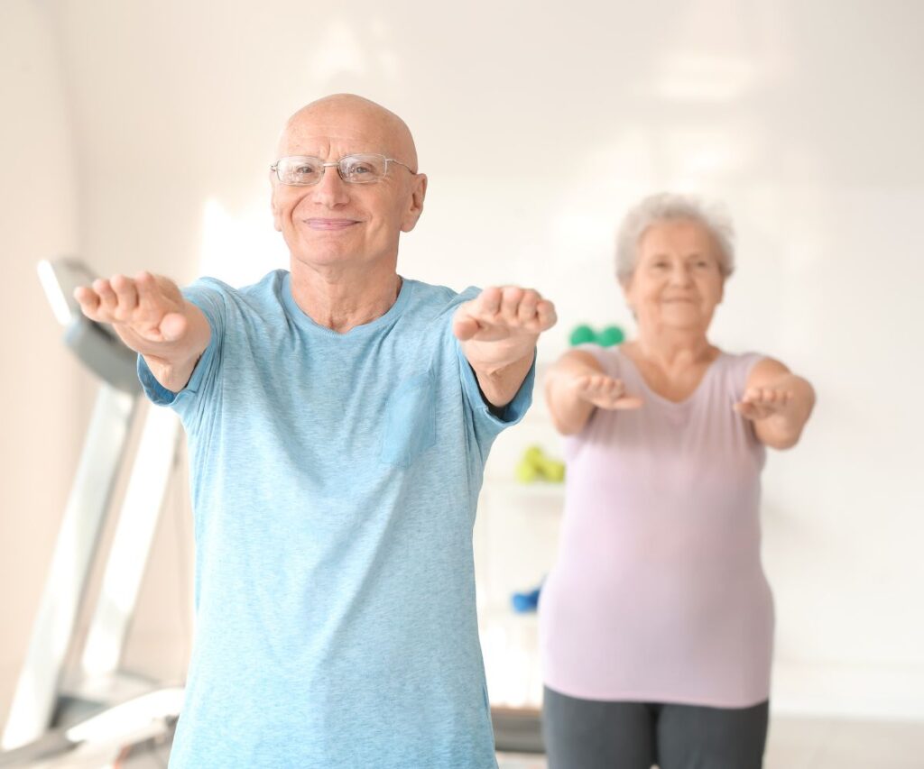 older couple with arms outstretched exercising