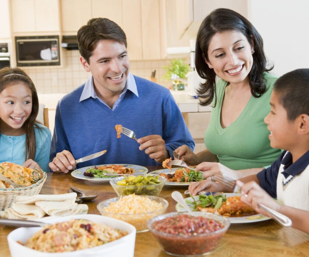 smiling family dad mom son daughter eating a meal together