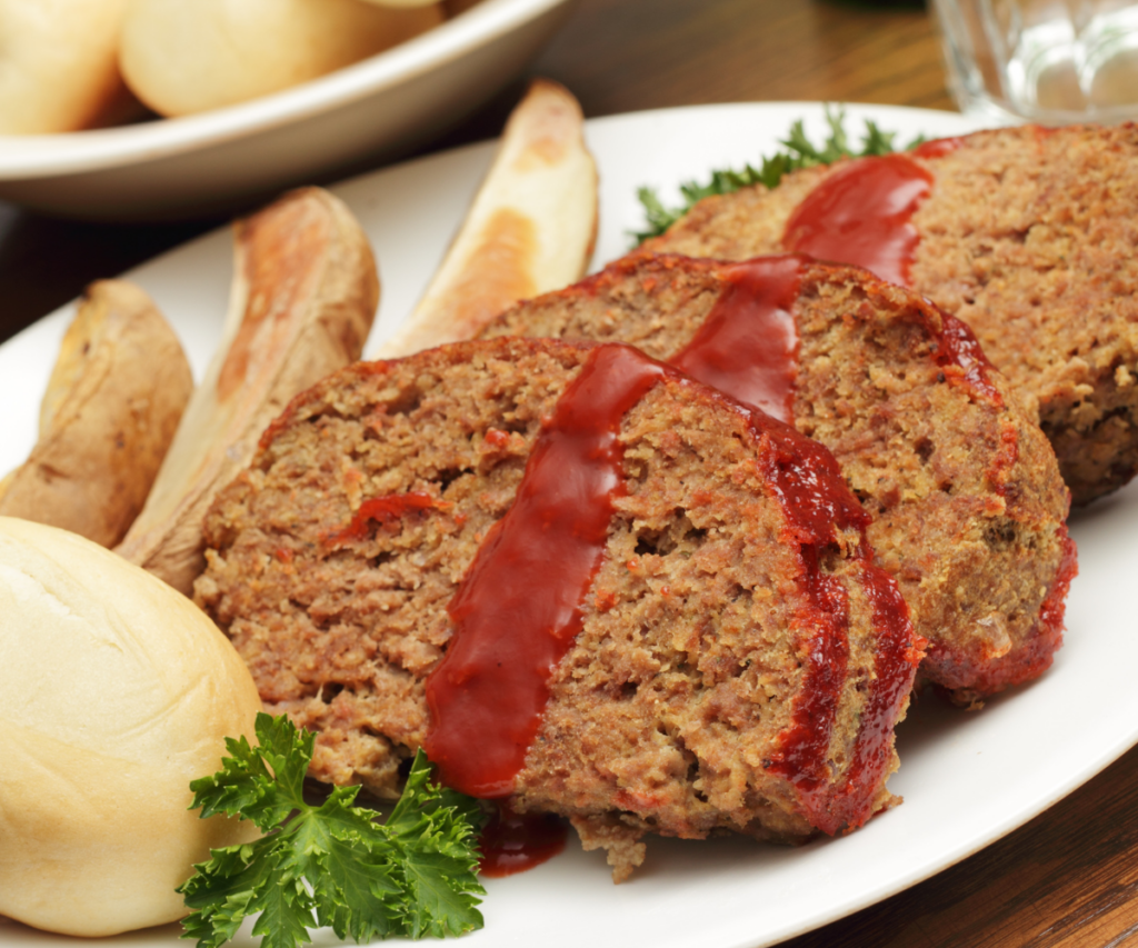 Meatloaf on a plate with sauce and mashed potatoes