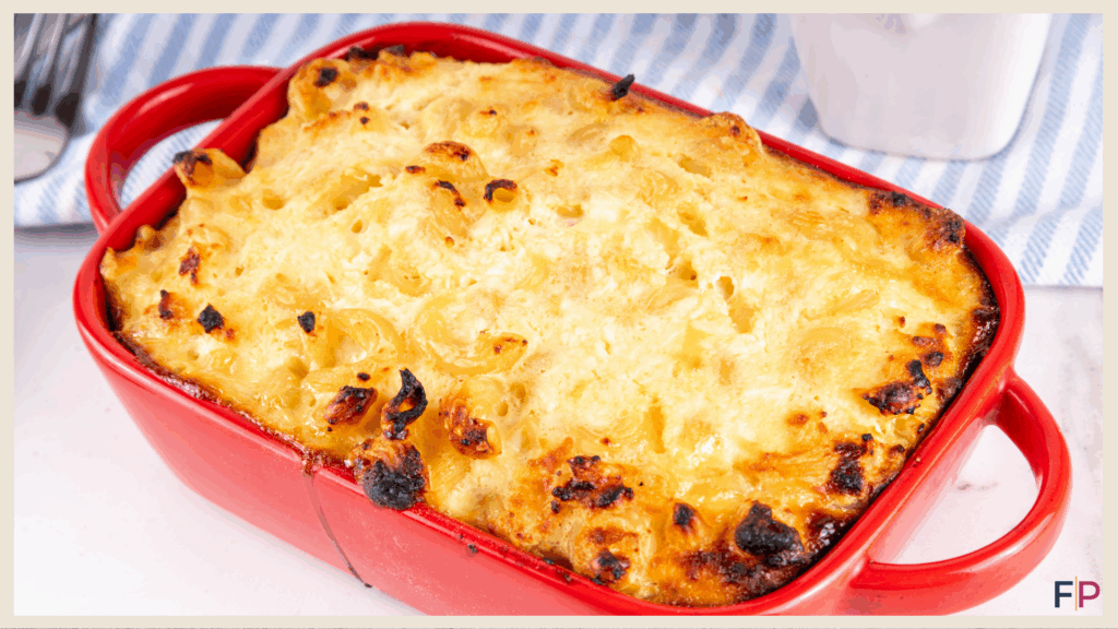 Pasta bake topped with cheese in a red casserole dish